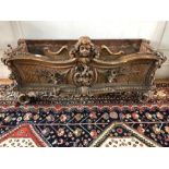 A 19th century carved giltwood planter trough in the rococo style, centred by a winged cherub over a