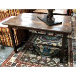 A 17th century oak plank top table, with cleated ends raised on a square section frame, united by