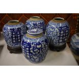 A set of four blue and white ginger jars, or other vessels; each one decorated with floral designs