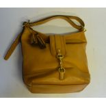 A Coach butter-soft light tan leather shoulder bag with gilt metal clasp and buckle and tassel