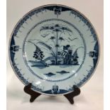 An 18th century English Delft blue and white shallow bowl decorated in the Chinoiserie style with