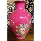 A Chinese ruby ground, famille rose vase with trumpet neck, decorated with a pair of birds on a