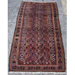 An Afghan Baluch rug, circa 1920, the central reserve with diamond motif on a brown ground and