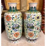A pair of Chinese doucai slender, oviform vases; each one decorated with birds and formal floral