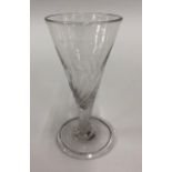 An 18th century short ale glass with drawn wrythen trumpet bowl and stem, comical fold over foot and