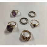 Six various rings comprising an oval claw set amethyst ring, 9ct yellow gold; a 9ct yellow gold