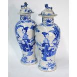 A pair of Chinese blue and white baluster vases; each one with an associated domed cover and