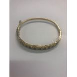 WITHDRAWN A 9ct yellow gold hinged bangle, half set with alternate rows of sapphires and diamonds,