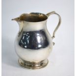 A silver baluster pear-shaped jug in the Georgian manner with scroll handle, Harman & Co., Jubilee