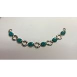 A contemporary white metal bracelet set with alternate oval turquoise with open links between,