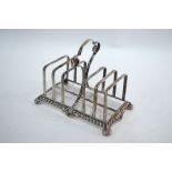 An Edwardian silver six-division toast-rack with scroll handle, gadrooned rim and bun feet, James