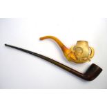 A 19th century meerschaum pipe carved as an eagle's claw and egg, on amber stem, to/w a