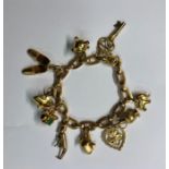 A yellow metal flat curb bracelet with 12 various charms attached including 21 key, shoes, elephant,
