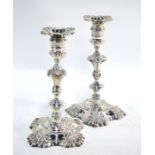 A pair of George II cast silver baluster candlesticks with floral engraving and embossed shell
