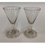 A pair of 18th century wine glasses - drawn trumpet bowl, short plain stem, conical fold over foot