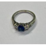A sapphire and diamond cluster ring, the central rectangular blue sapphire with a square cut diamond