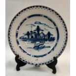 An 18th century English Delft blue and white charger decorated in the chinoiserie style with