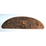 An antique relief-carved arched frieze, marked with scrolls, fruit and flowers, 32 x 107 cm