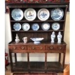 An 18th century joint oak high dresser, the plank back rack over three frieze drawers raised on