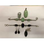 Two contemporary bracelet, ring and pendant sets, one green stone and white metal and one black