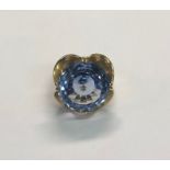 A large retro-style flower ring, the central circular blue topaz on flower shaped 9ct yellow gold