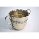 A white metal two-handled cup with rope-moulded waist; unmarked and untested, 9 cm high
