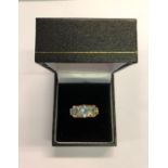 A three stone ring set three graduated blue stones in yellow metal claw setting, stamped 750, size