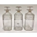 A set of three square cut glass decanters with chamfered corners and star cut bases, 24 cm high (3)