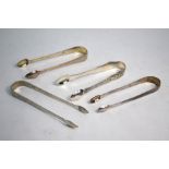 Three pairs of George III silver plain sugar tongs and an Edwardian pair of sugar tongs, cast and