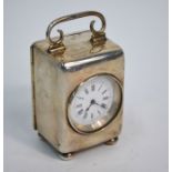 A late Victorian silver boudoir clock with French movement and enamel dial, top swing handle and bun