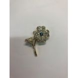 WITHDRAWN A modern diamond and sapphire set flower brooch, the four petalled flower set overall with
