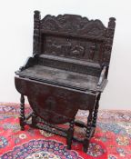 A 19th century low countries carved oak side table, the raised back carved with dragons, mermaids,