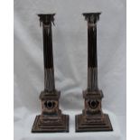 A pair of silver plated on copper candlesticks, with a stop fluted ionic column and square base, 36.