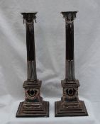 A pair of silver plated on copper candlesticks, with a stop fluted ionic column and square base, 36.