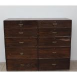 A Stained pine chest, the rectangular top above ten short graduated drawers 148cm wide x 53.