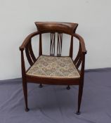 An Edwardian mahogany elbow chair of horseshoe shape with pierced splats and a pad seat on tapering
