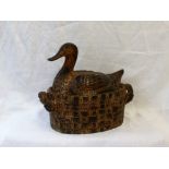 A pottery duck and basket terrine, in mottled browns,