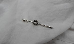 A diamond bar brooch set with a round old cut diamond, approximately 1.