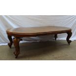 A Victorian mahogany extending dining table of oval form on heavy cabriole legs,