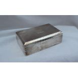 A George V silver cigarette box of rectangular form, with a central initialled cartouche,