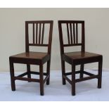 A pair of 18th century provincial oak dining chairs with stick backs above a solid seat on square