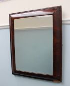 An 18th century walnut wall mirror with a cushion frame, of rectangular form,