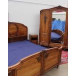 A French walnut armoire with a carved floral cornice above a central mirrored door and two panel