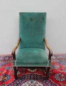 An 18th century library chair with a pad upholstered back and seat with scrolling arms,