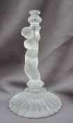 A Baccarat glass lamp base in the form of a cherub holding a candle holder on a circular base 27cm