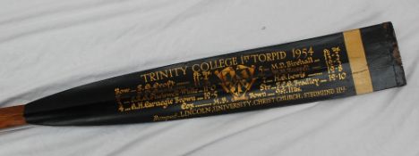 A full length oar, the blade painted black with gilt script for "Trinity College 1st Torpid 1954,