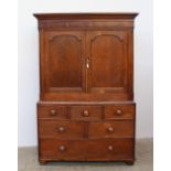 An 18th century oak linen press, the moulded cornice above a shallow frieze and two panelled doors,