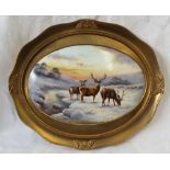 A Milwyn Holloway porcelain plaque of oval form painted with deer in a snowy landscape, signed M.