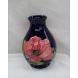 A Moorcroft pottery vase decorated in the Magnolia pattern to a blue ground,