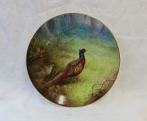 A Minton porcelain plate painted with a cock and hen pheasant in a woodland signed by A H Wright